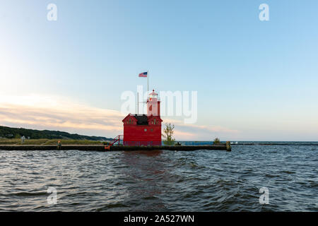 Grande faro rosso come il sole sorge su una bella mattina di autunno. Holland, Michigan, Stati Uniti d'America Foto Stock