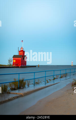 Grande faro rosso come il sole sorge su una bella mattina di autunno. Holland, Michigan, Stati Uniti d'America Foto Stock