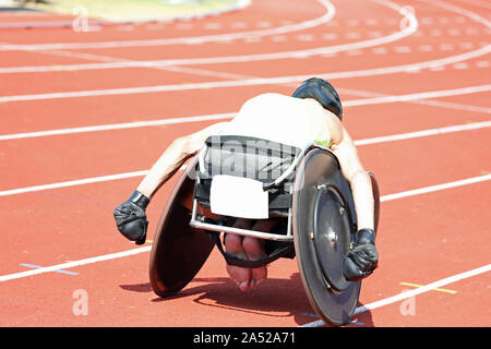 Giovane atleta sulla sedia a rotelle durante una gara a sport venue Foto Stock