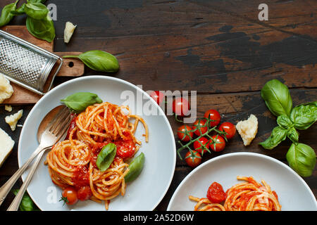 Spaghetti con salsa di pomodoro, il basilico e il formaggio su una tavola di legno Foto Stock