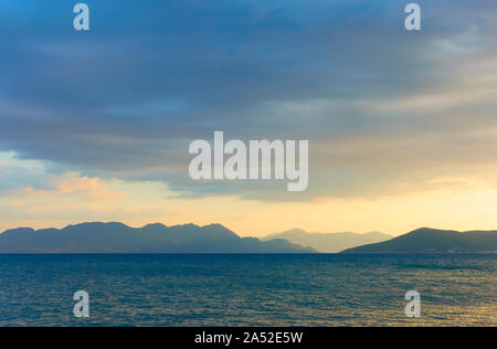 Vista pittoresca con il mare, le nuvole e le isole all'orizzonte al tramonto -- Sunset seascape - paesaggio Foto Stock