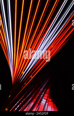 Abstract festosa verticale con sfondo rosso, arancione e bianco strisce LED su uno sfondo nero per la progettazione sul tema del Natale e Anno Nuovo, disco