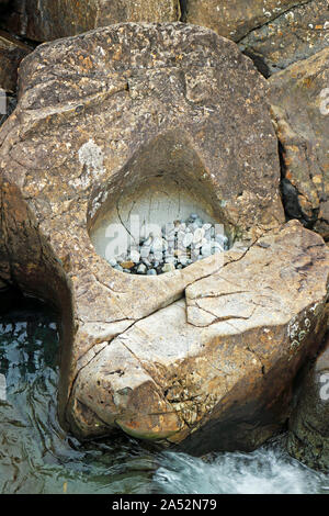 Un waterworn buca con ciottoli a Allt un cocco Mhadaidh presso la fata piscine sull'Isola di Skye in Scozia, Regno Unito, Europa. Foto Stock