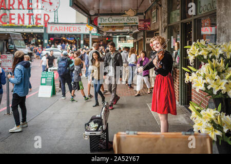 Musicista di strada in abito rosso suona violino presso il Mercato di Pike Place Foto Stock