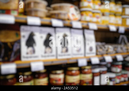 Blur defocalizzata vista di scaffale di supermercato vende diverse ciotole con frutta e conserve vegetali Foto Stock