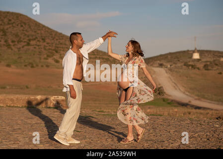 Donna incinta con il marito ballare insieme Foto Stock