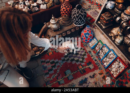 Bambina gioca con un gattino nell'Oriental Bazaar Foto Stock