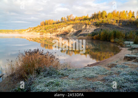 La riva del lago di nebbia al mattino presto illuminata dal sole luminoso . Paesaggio autunnale.Vsevolozhsk, regione di Leningrado. Foto Stock