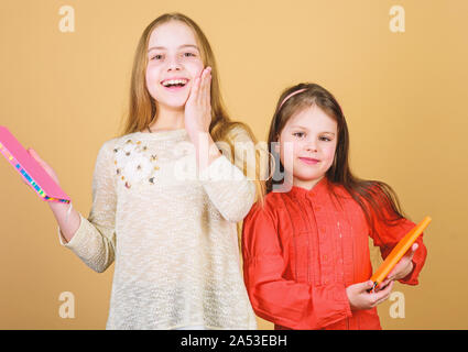 Favola preferita. Sorelle pick libri da leggere insieme. Adorabili ragazze amano i libri. Diari segreti o un diario personale. Smart è grande. I ragazzi ragazze con libri e quaderni. Educazione e letteratura per bambini. Foto Stock