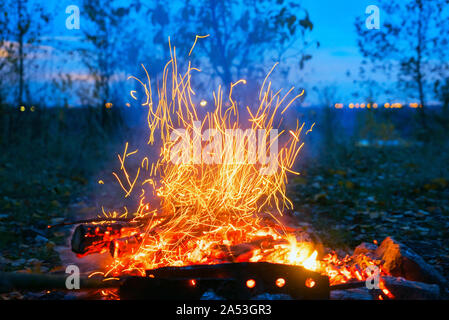 Rosso fiamma di fuoco nel buio serale su sfondo blu Foto Stock