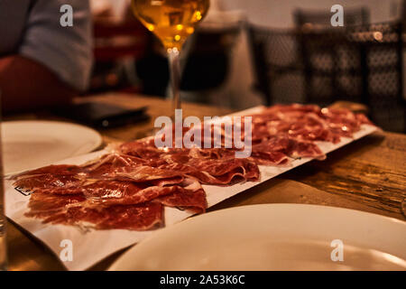 Piatto di prosciutto spagnolo affettato con un bicchiere di birra al ristorante e microbirrificio Basquery, Bilbao, Spagna Foto Stock