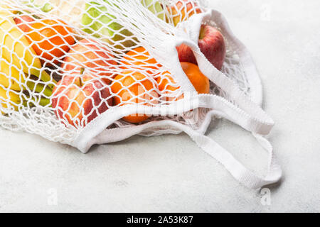 Rifiuti Zero eco friendly shopping concetto, frutta verdura in bianco borsa a rete su bianco tavolo da cucina, il fuoco selettivo Foto Stock