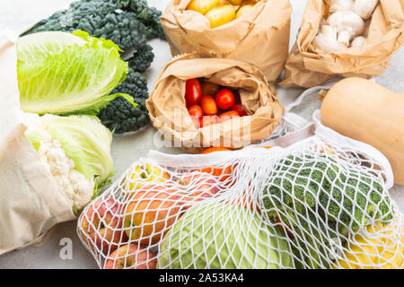 Rifiuti Zero eco friendly shopping concetto, frutta verdura in maglia bianca di cotone e sacchi di carta bianca sul tavolo da cucina, il fuoco selettivo Foto Stock