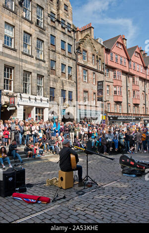 Strada musicista esecutore e pubblico sulla Royal Mile. Edinburgh Fringe Festival Scozia Foto Stock