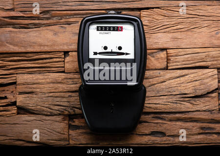 Close-up di un kilowatt contatore elettrico sulla scrivania in legno Foto Stock