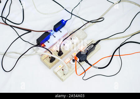 Sovraccarico di più schede di potenza, presa completa prolunga. Bianco sfondo isolato. Foto Stock