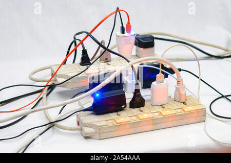 Sovraccarico di più schede di potenza, presa completa prolunga. Bianco sfondo isolato. Foto Stock