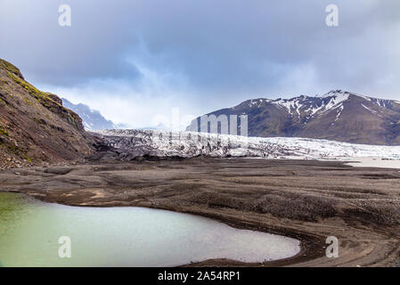 Skaftafellsjokull ghiacciaio con montagne e lago verde nella parte anteriore, Vatnajokul national park, Sud Islanda Foto Stock