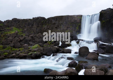 Cascata Oxararfoss ruscelli cadendo dalla montagna, Tingvellir National Park, Islanda Foto Stock