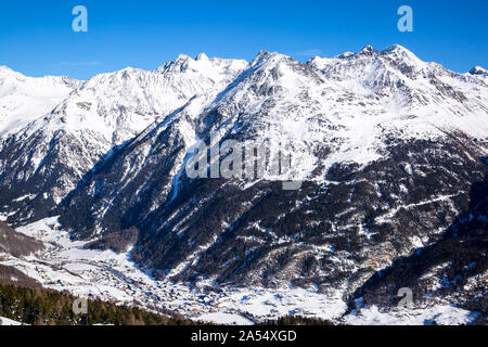 Alpi rocciose, coperto di neve. Il villaggio di sci nella valle. Inverno bella vista panoramica in Tirol, Austria. Foto Stock