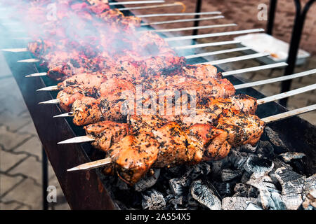 Hot grigliate di carne di maiale o kebab kebab barbecue a carbone sfondo con erbe aromatiche e spezie da vicino. Foto di maiale alla brace cubi decorate con peperoncino Foto Stock