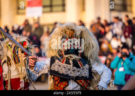 Mummers eseguire rituali per spaventare gli spiriti malvagi a Surva festival di Pernik in Bulgaria. Le persone sono chiamati Kuker, kukeri. Maschera da lana. Foto Stock