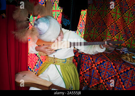 Donna asiatica in abito tradizionale svolge un presentate spennate strumento musicale. Festival delle culture tradizionali in Altai. Barnaul. 7 Settembre 2019 Foto Stock