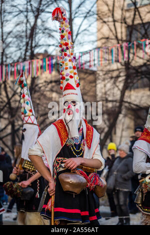 Mummers eseguire rituali per spaventare gli spiriti malvagi a Surva festival di Pernik in Bulgaria. Le persone sono chiamati Kuker, kukeri. Maschera con mustaches. Foto Stock