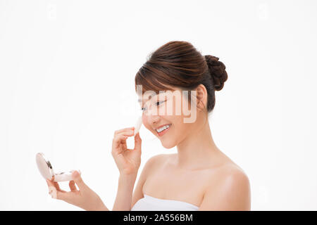 Donna l'applicazione di polvere cosmetica puff sul suo viso Foto Stock