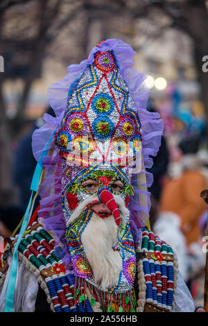 Mummers eseguire rituali per spaventare gli spiriti malvagi a Surva festival di Pernik in Bulgaria. Le persone sono chiamati Kuker, kukeri.Colorata e splendente maschera. Foto Stock