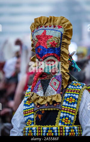 Mummers eseguire rituali per spaventare gli spiriti malvagi a Surva festival di Pernik in Bulgaria. Le persone sono chiamati Kuker, kukeri. Motley maschera. Foto Stock