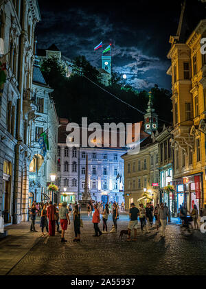 Lubiana durante la notte con il castello e la luna in background. La Slovenia Foto Stock