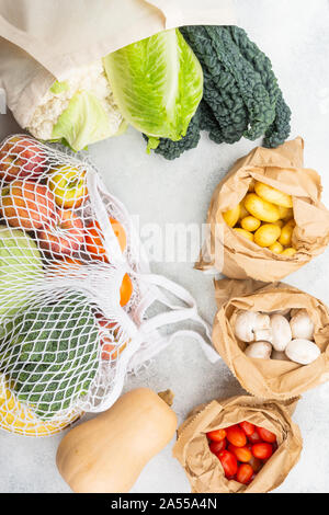 Rifiuti Zero eco friendly shopping concetto, frutta verdura in maglia bianca di cotone e sacchi di carta bianca sul tavolo da cucina, vista dall'alto, il fuoco selettivo Foto Stock