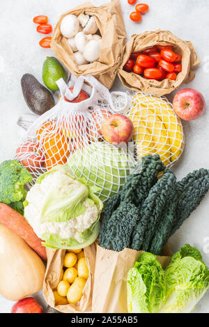 Rifiuti Zero eco friendly shopping concetto, ortaggi frutta disposizione in maglia bianca di cotone e sacchi di carta bianca sul tavolo da cucina, vista dall'alto, il fuoco selettivo Foto Stock