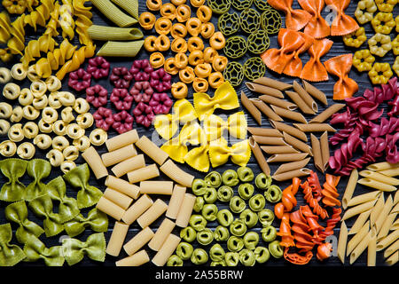 Diversi tipi di pasta nero su sfondo in legno, cucina italiana. Foto Stock