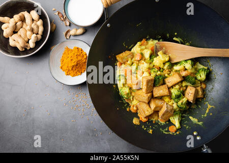 Agitare wok fritto tofu e verdure con salsa satay. Vista superiore Foto Stock