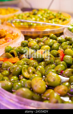 In casa decapati olive verdi con aglio e spezie in cucchiaio sul mercato spagnolo Foto Stock