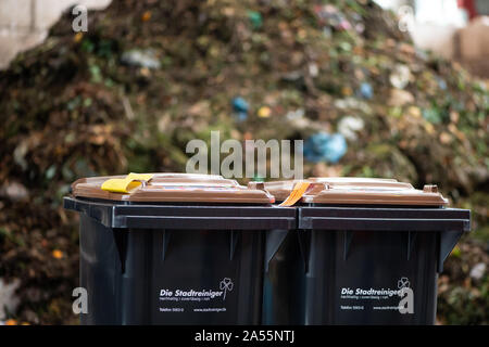 Kassel, Germania. Xviii oct, 2019. Due scomparti biowaste sostare davanti a un mucchio di composto a Kassel rifiuti da impianti di energia. A partire da giugno 2018, i valori limite per le impurità in biowaste sono state serrate in modo significativo. Sacchetti di plastica, imballaggio e gli altri rifiuti residui mettono in pericolo il riciclaggio di rifiuti organici in Kassel. Credito: Swen Pförtner/dpa/Alamy Live News Foto Stock