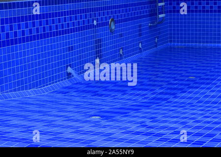 Movimento sfocate di acqua che fluisce dal tubo di sbocco nel vuoto la piscina dopo la ristrutturazione e il processo di pulizia, il fuoco selettivo Foto Stock