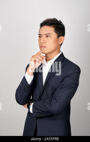 Ritratto di attraente giovane imprenditore asiatico è confusa su sfondo bianco Foto Stock