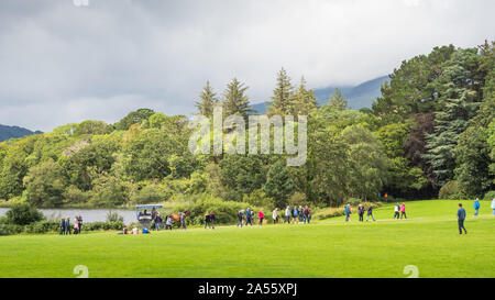 KILLARNEY, Irlanda - Agosto 13, 2019: Turisti in una tradizionale macchina jaunting esplorare Killarney National Park nella contea di Kerry, Irlanda. Foto Stock