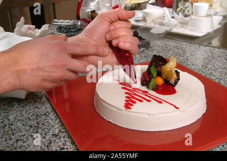 Pastry chef decora un bavarese crema torta. Foto Stock