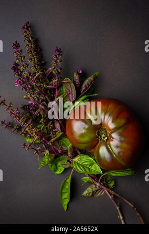 Vista aerea di un cimelio di pomodoro e un gambo fresco di basilico tailandese Foto Stock