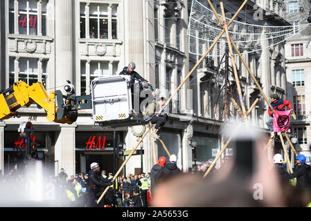 Londra, Regno Unito. Xviii oct, 2019. Un cambiamento climatico protestor viene rimosso da una rudimentale struttura costruita a Londra, in Oxford Circus. Credito: Kevin Shalvey/Alamy Live News Foto Stock