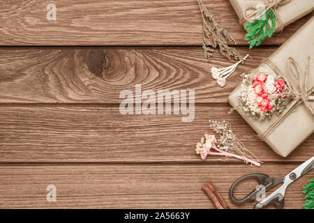 Realizzato a mano DIY regalo di Natale scatola su uno sfondo di legno. Presente naturale scatole per Natale e Capodanno o altro anniversario. Biglietto di auguri con copia sp Foto Stock