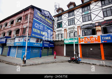 Srinagar, India. Xviii oct, 2019. Una donna cammina passato negozi chiusi durante lo spegnimento in Srinagar.valle del Kashmir hanno continuato a rimanere chiuso il settantacinquesimo giorno consecutivo contro l'abrogazione dell'articolo 370 dal governo centrale che concede lo status speciale di Jammu e Kashmir. Credito: SOPA Immagini limitata/Alamy Live News Foto Stock