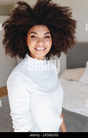 Felice giovane donna con acconciatura afro in camera da letto, vita ritratto Foto Stock