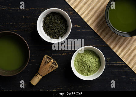 Ancora in vita di matcha preparazione del tè con frusta e ciotole di matcha tè e polvere di tè, vista aerea Foto Stock