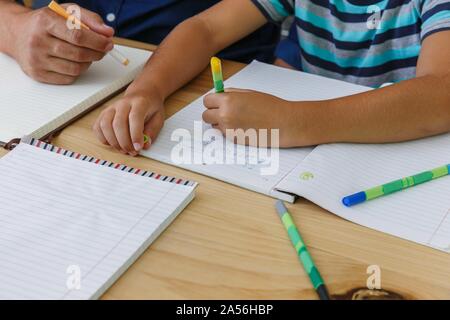 Padre aiutando figlio con i compiti a casa Foto Stock