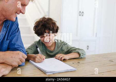 Padre aiutando figlio con i compiti a casa Foto Stock
